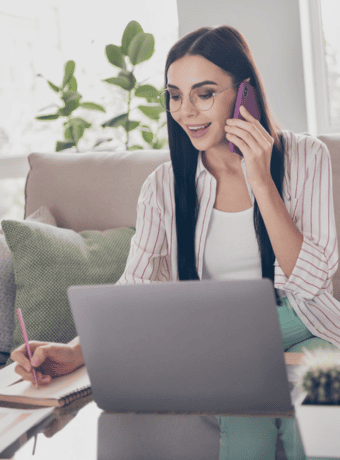 Woman on phone writing down notes
