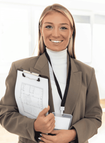 Professional woman holding a clipboard with building plans