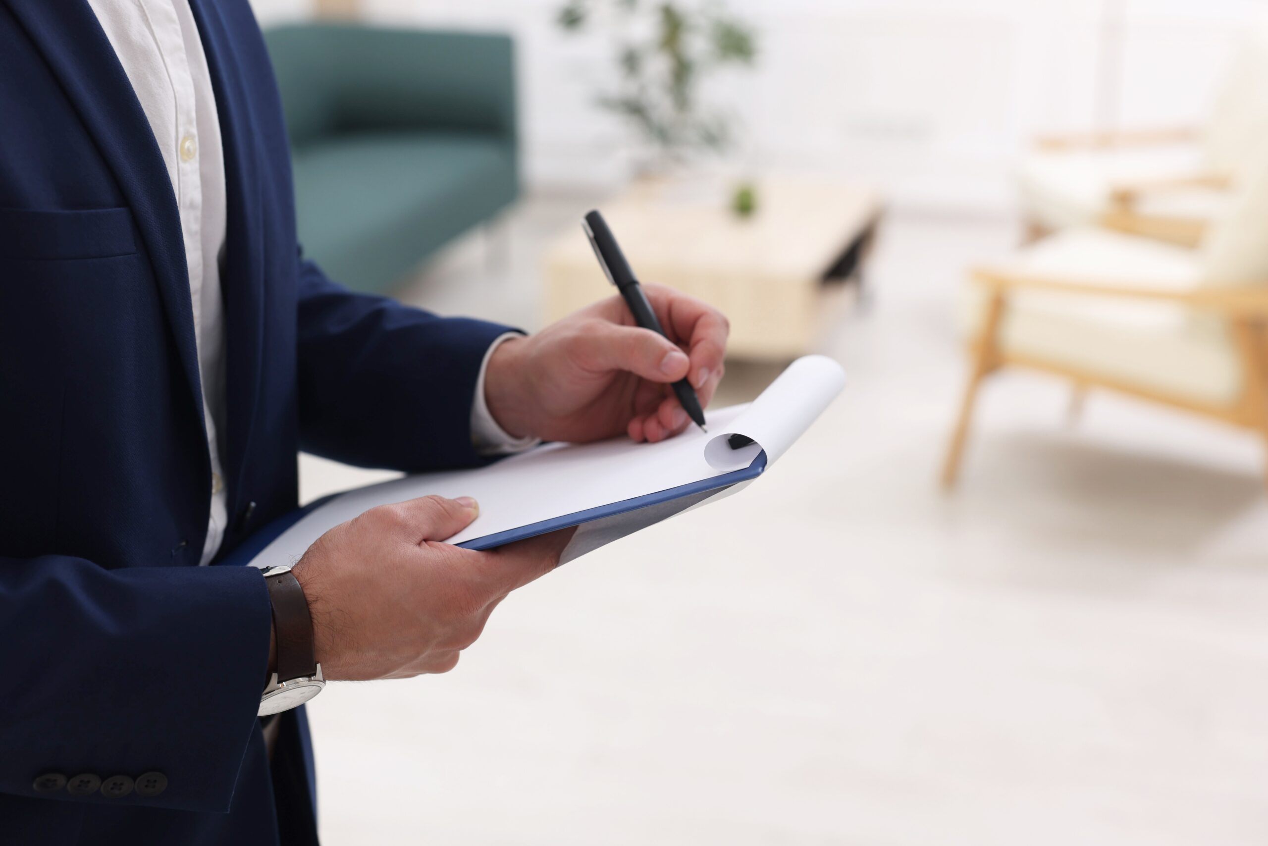Professional signing paperwork on a clipboard indoors